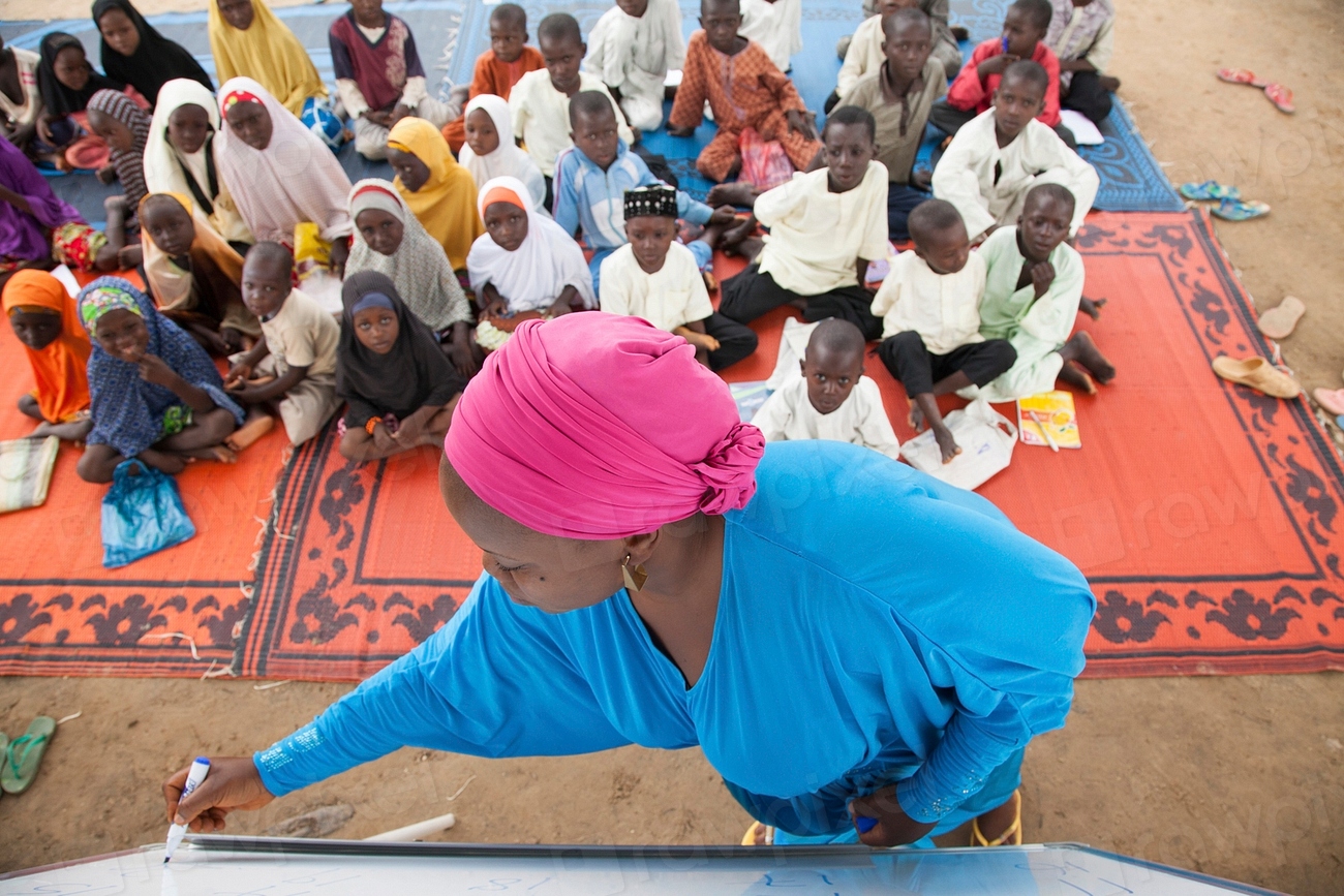 Teacher helping students learn to read and write